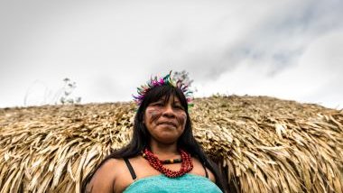 Imagem de uma mulher índigena, usando um cocar pequeno de penas coloridas e um colar feito com semestes naturais, simbolizando a cabocla Jarina da Umbanda.