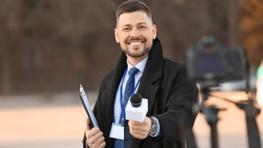Imagem de um jornalista homem se preparando para fazer uma entrevista para a TV.