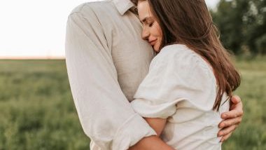 Imagem de um casal se abraçando, após uma crise de ciúmes e ao fundo um lindo campo verde.