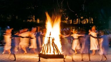 Imagem de um terreiro com uma fogueira e várias pessoas dançando em volta do fogo. A imagem traz o conceito sobre falanges da Umbanda.