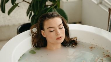 Imagem de uma mulher deitada em uma banheira com água e ervas, fazendo o ritual do Amaci na Umbanda.