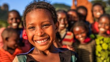 Imagem com várias crianças negras. Em destaque, uma que está bem alegre. Ela simboliza a Erê Terezinha.