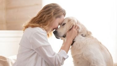 Imagem de uma mulher acariciando o seu cachorro, mostrando o seu lado nobre com os animais.