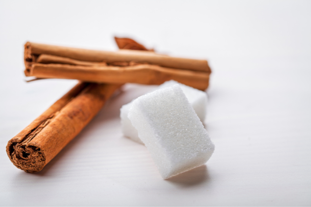Paus de canela e blocos de açúcar em uma mesa