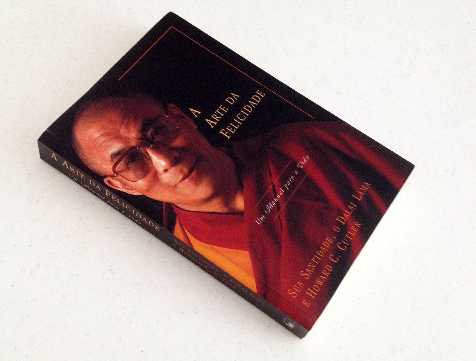 Livro A arte da felicidade em uma mesa