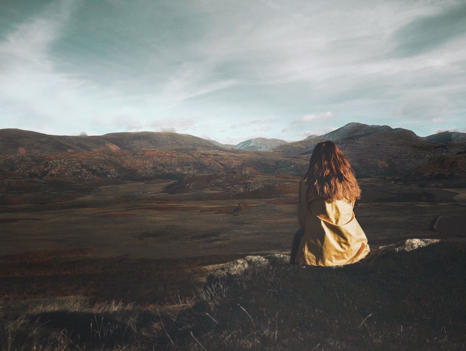 Mulher sentada num campo.