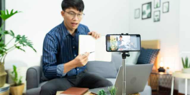 Professor de óculos sério ensinando alunos virtualmente