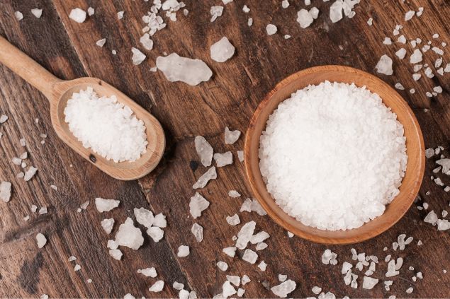 Sal grosso espalhado em cima de uma mesa de madeira