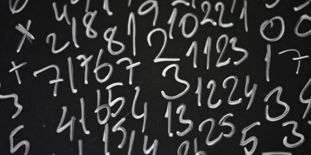 Números de giz branco desenhados na lousa