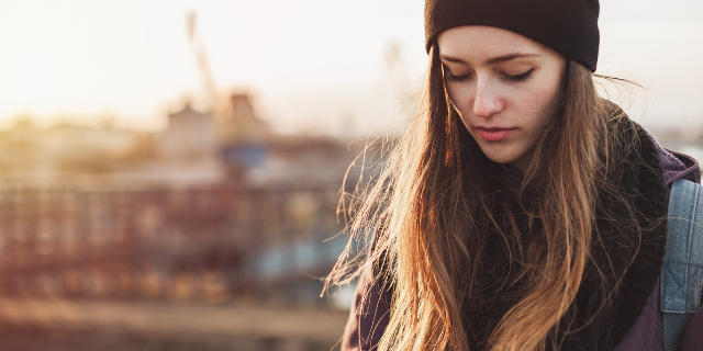 Garota andando triste pela cidade