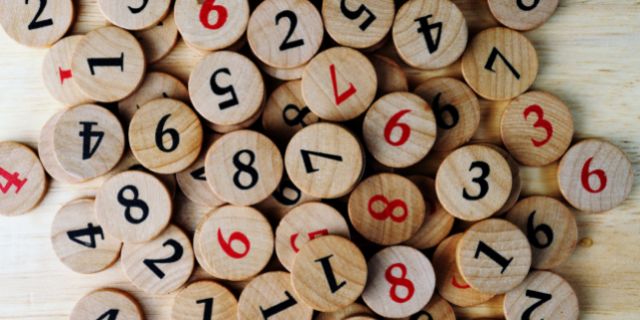 números gravados em pedaços de madeira