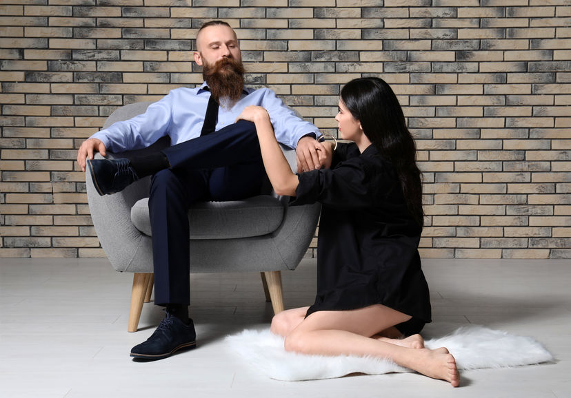 Mulher ajoelhada ao lado de homem com roupa social