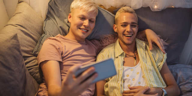 Casal abraçados e sorrindo deitados na cama