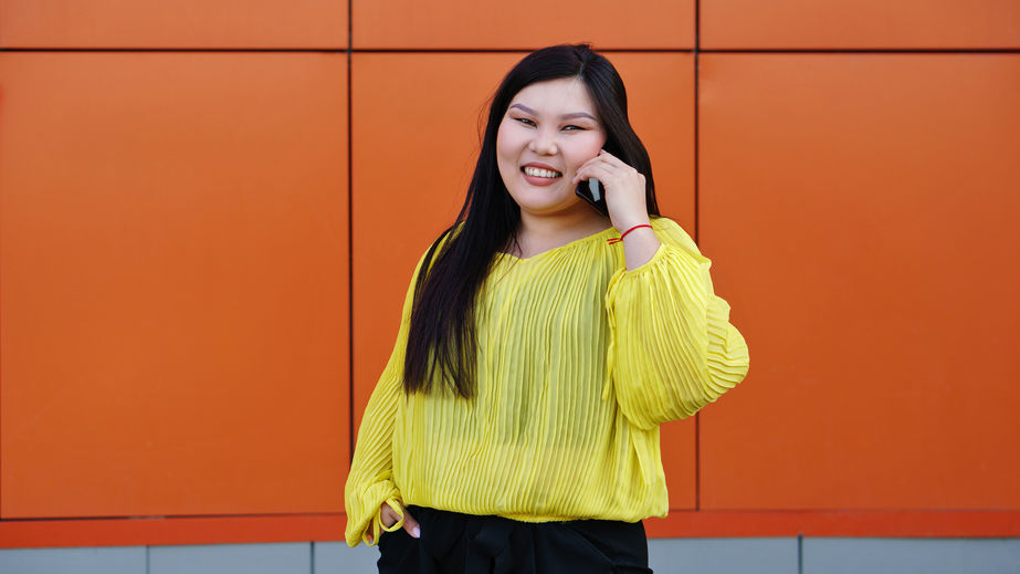 Mulher segurando celular e sorrindo 
