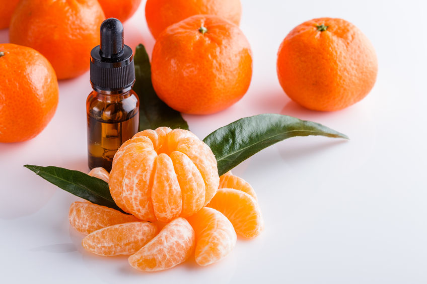 Pote de óleo essencial com mexericas ao lado.