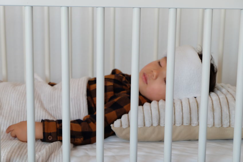 Criança em berço de olhos fechados