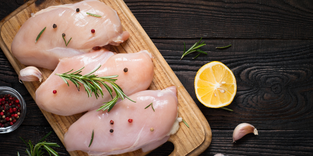Filés de frango cru na tábua de madeira