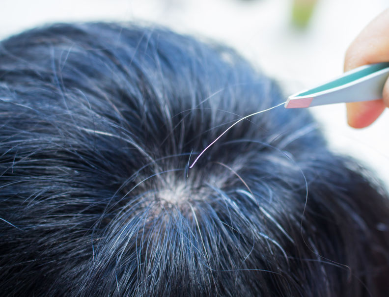 Pessoa arrancando fio branco