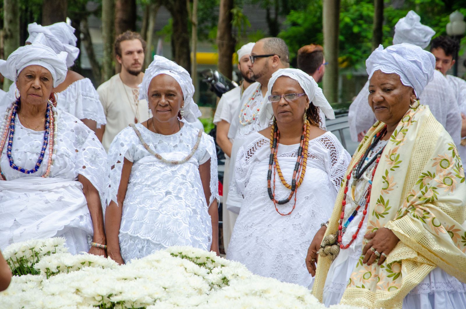 Umbandistas em frente a flores 