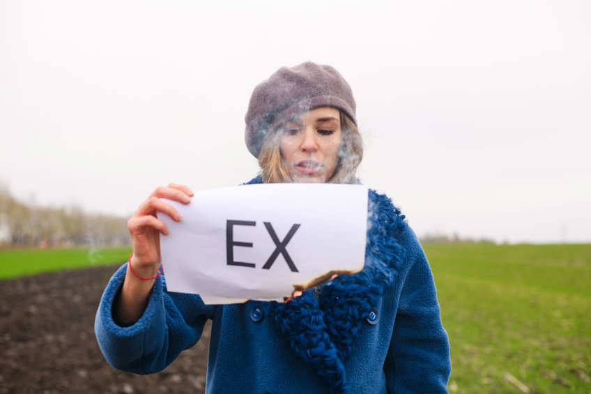 Mulher branca segurando folha escrito 