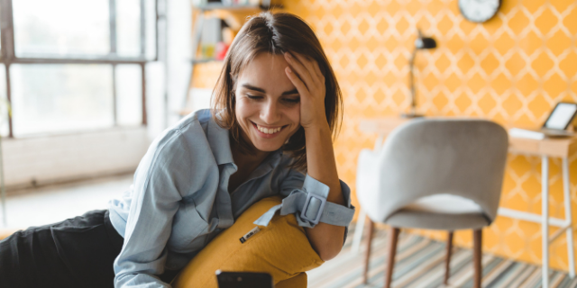 Mulher feliz olhando para o seu telefone