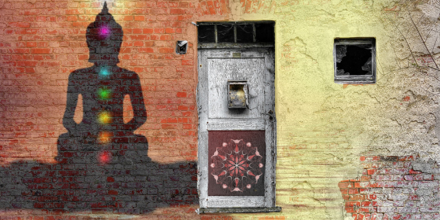 parede de tijolo com chakaras pintados e uma porta ao lado