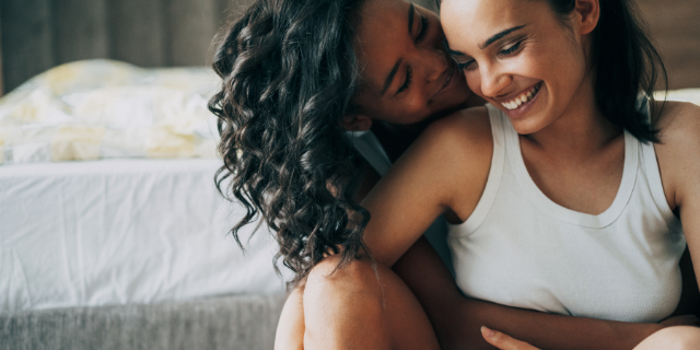 Casal abraçadas juntas na cama do quarto