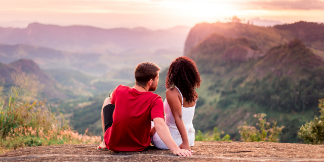 Casal de namorados de mãos dadas no topo da montanha