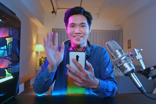 Homem fazendo stream sorrindo para câmera