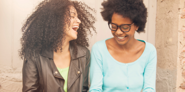 Duas amigas rindo juntas e conversando