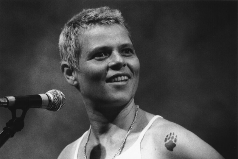 Cantora Cássia Eller com microfone ao lado.