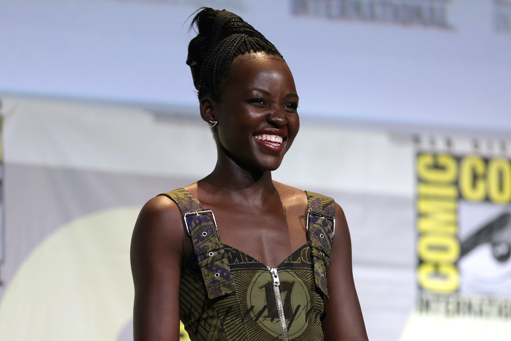 Lupita Nyong'o sorrindo no palco