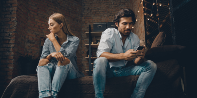 casal brigado sentados na cama de costas um para o outro