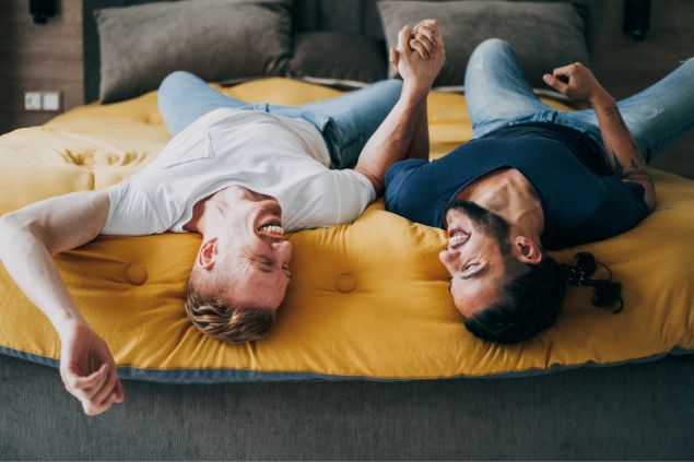 casal deitados na cama de mãos dadas