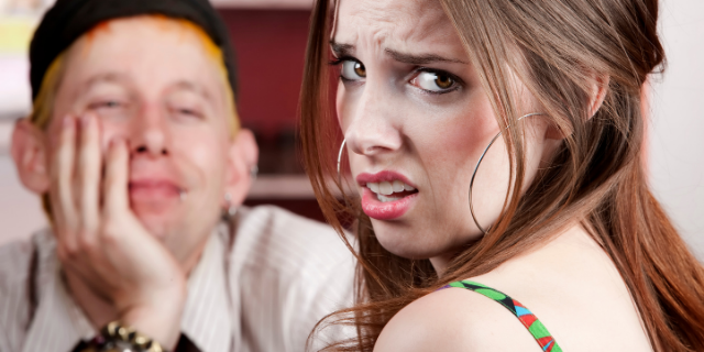 Casal em um encontro ruim com a mulher fazendo careta enquanto o homem a encara apaixonado