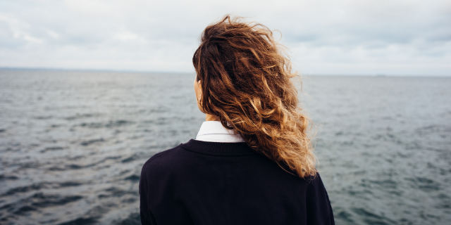 Mulher pensativa olhando para o mar