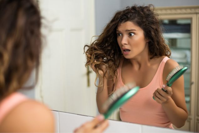 Mulher surpresa com queda de cabelo