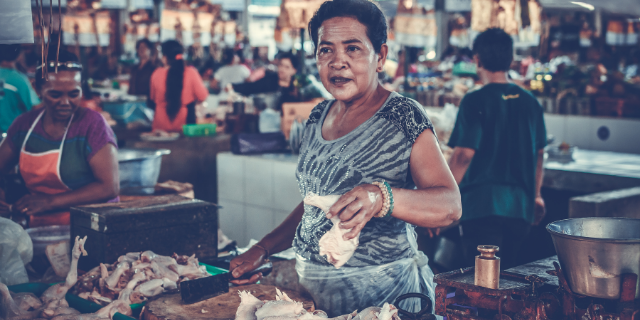 Vendedora sorrindo em sua loja vendendo algo