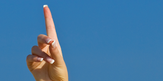 Pessoa fazendo o número um com as mãos