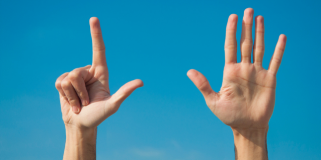 pessoa fazendo o número sete com as mãos