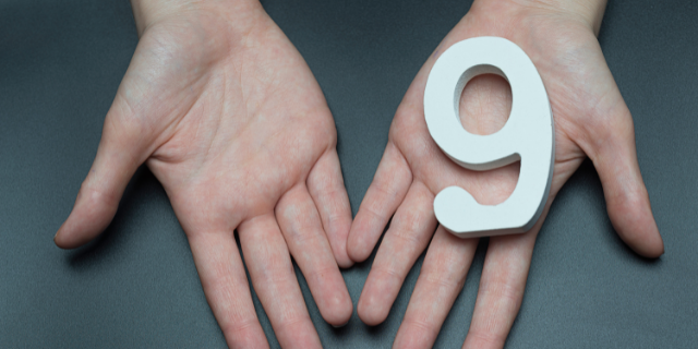 Mão estendida segurando o número 9