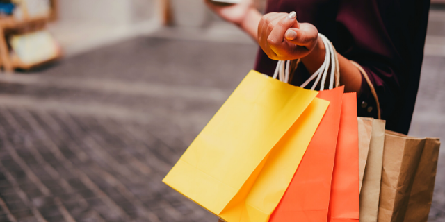 Mulher segurando várias sacolas de compra