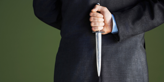 Homem vingativo segurando uma faca atras das costas