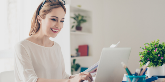 Professora sorrindo enquanto leciona em aula virtual