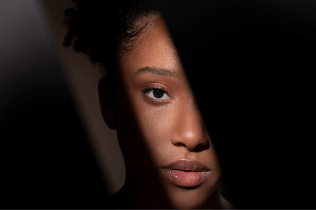 Mulher negra com um feixe de luz sob o rosto
