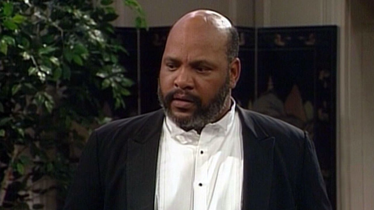 Homem negro careca de barba preta, vestindo um smoking.