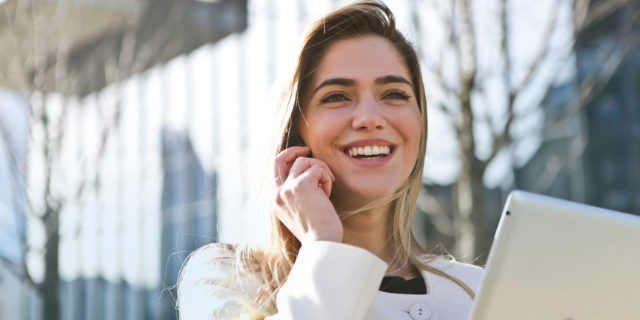 Mulher sorrindo enquanto fala no telefone