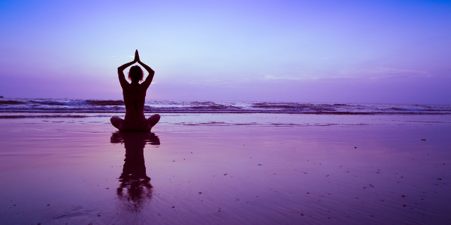 Mulher fazendo yoga na praia