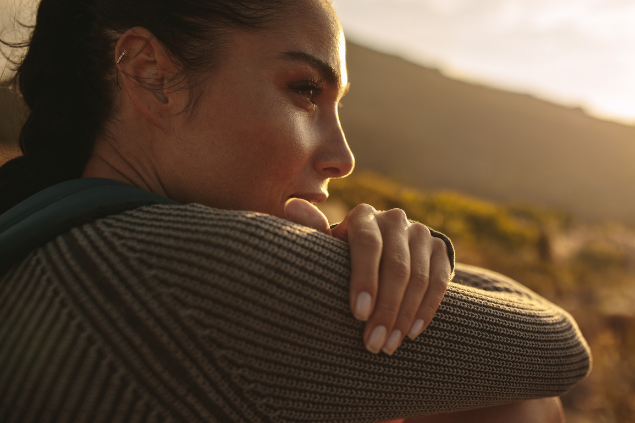 Mulher olhando reflexiva para o horizonte