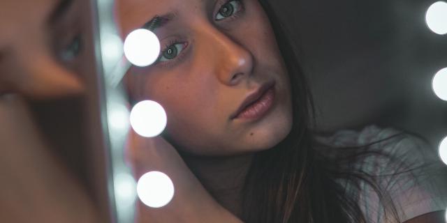 Garota se arrumando olhando no espelho